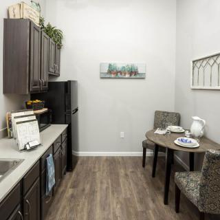 A modern kitchen interior with dark cabinets, a small dining area, and contemporary decor.
