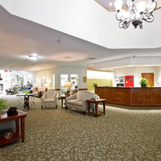 A spacious hotel lobby with a reception desk and comfortable seating.