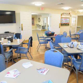 A bright dining area with tables and chairs set for a meal.