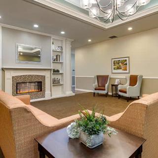 A cozy living room with a fireplace, armchairs, and a sofa, featuring elegant interior design elements.