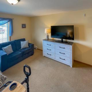 A cozy living room with a blue sofa and television on a dresser.