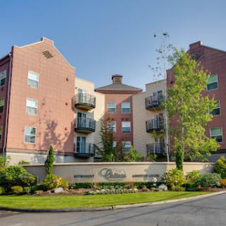 A modern residential apartment building with balconies and landscaped surroundings.