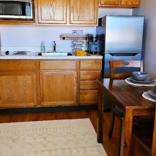 A cozy kitchen featuring wooden cabinets, modern appliances, and a small dining area.