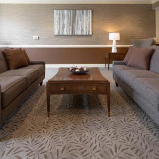 A cozy living room setup featuring two sofas, a wooden coffee table, and ambient lighting.