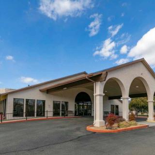 Exterior view of a hotel with arched entrance under a clear blue sky.