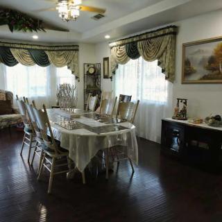 A well-decorated dining room with an elegant table setting and ornate curtains.