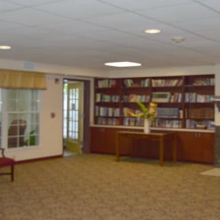 A library reading room with bookshelves and comfortable seating.