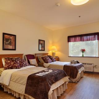 A cozy bedroom with two twin beds, warm lighting, and decorative elements.