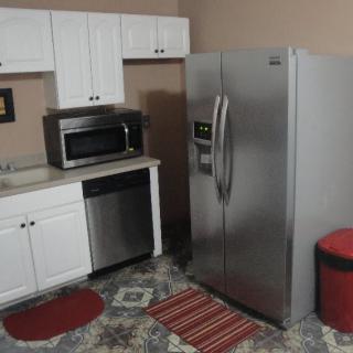 A modern kitchen area with stainless steel appliances and white cabinets.