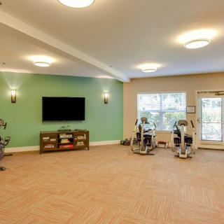 A spacious gym with exercise equipment and a television.