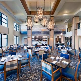 A modern restaurant interior with elegant chandeliers and a spacious dining area.