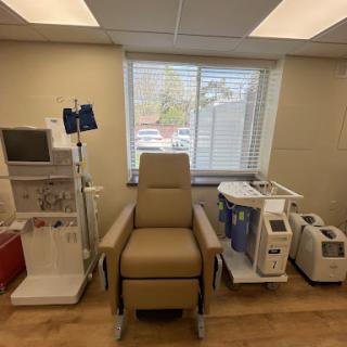 A well-equipped medical treatment room featuring a comfortable patient chair and monitoring equipment.