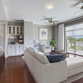 A modern and spacious living room featuring a comfortable sofa, large windows, and elegant decor.