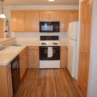 A cozy kitchen with wooden cabinets and modern appliances.