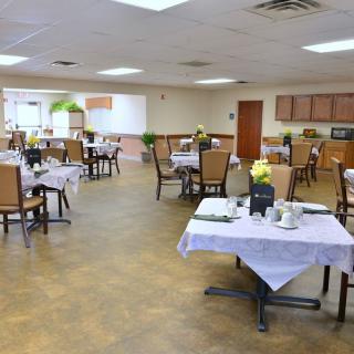 An empty dining room with neatly arranged tables and chairs.