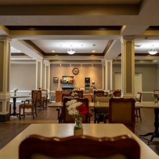 An elegantly designed dining area with tables and chairs, well-lit by ceiling lights.