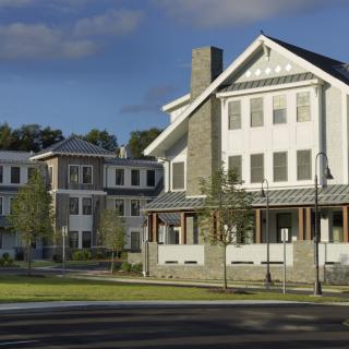A modern suburban residential building with a stone facade and large windows.