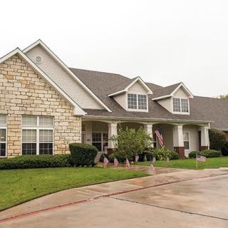 A suburban house with a stone facade and a neatly maintained front yard.
