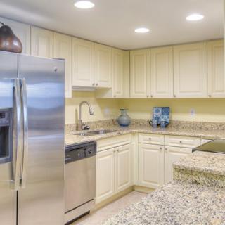 A modern kitchen with stainless steel appliances and light cabinetry.
