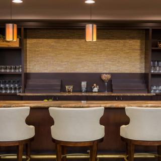 A modern bar interior with wooden seating and ambient lighting.