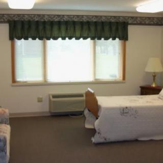 A minimalist hospital room with a single bed and a window.