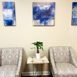 A cozy waiting area featuring modern artwork and stylish seating.