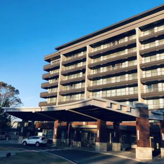 A modern hotel building with multiple balconies and a covered entrance.