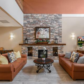 A cozy living room with a stone fireplace and comfortable seating.