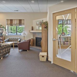 A cozy living room with comfortable seating, a fireplace, and large windows.