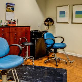 An interior view of a salon with blue chairs and hairdressing equipment.