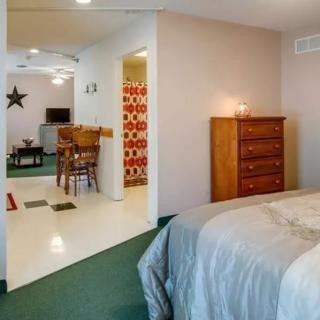 A cozy bedroom with an open layout leading to a dining area.