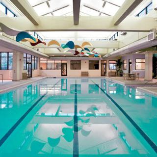 A spacious indoor swimming pool with a skylight and decorative ceiling.