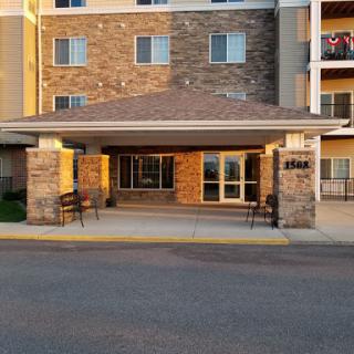 The inviting entrance of a residential building, showcasing its modern design and stone accents.