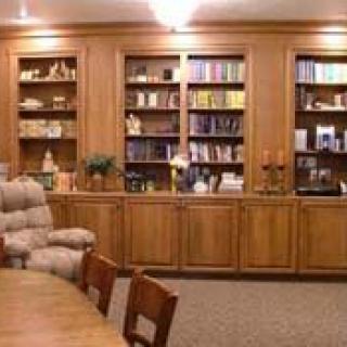 A cozy library with wooden bookshelves filled with books and comfortable seating.
