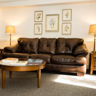 A cozy living room setup featuring a brown sofa, wooden coffee table, and decorative wall art.