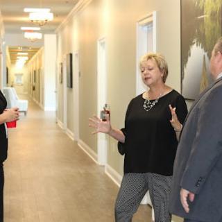 Three people engaged in a conversation in a hallway.