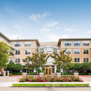 A modern residential building with landscaped gardens and a welcoming entrance.