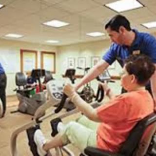 A therapist assists a patient during a physical therapy session in a rehabilitation center.