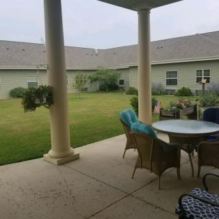 A cozy patio with outdoor seating overlooking a well-maintained garden.