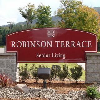 Entrance sign for Robinson Terrace Senior Living surrounded by landscaping.