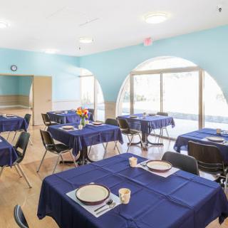 A beautifully arranged dining area with blue tablecloths and a spacious atmosphere.