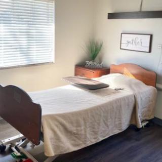 A serene spa room with a massage table by the window, bathed in natural light.