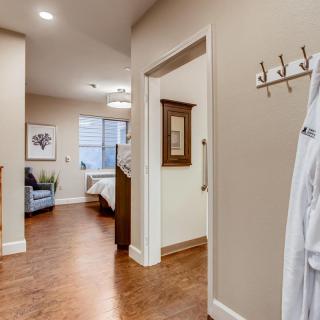 A cozy and inviting bedroom view from the hallway, featuring elegant home decor and wooden flooring.