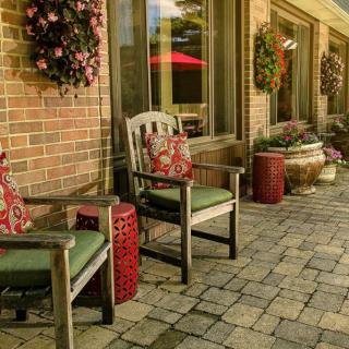 A cozy patio with comfortable chairs and decorative potted plants.