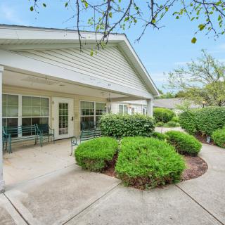 A peaceful backyard patio with neatly trimmed shrubs and outdoor seating.