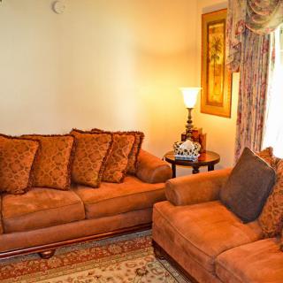 A cozy living room with brown sofas, a lamp, and decorative elements.