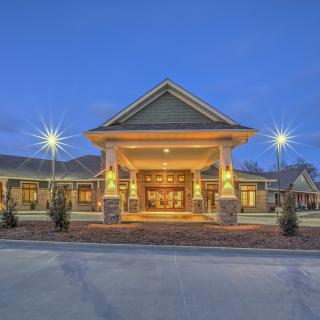 An illuminated building entrance at dusk, showcasing its architectural design.