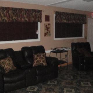 A cozy living room with leather recliners and decorative window treatments.