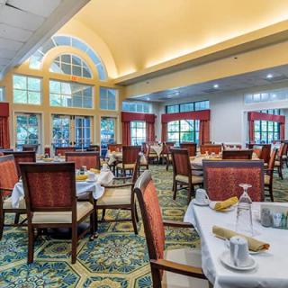 A spacious dining room with elegant decor and neatly set tables ready for guests.