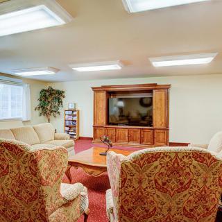 A cozy living room with comfortable seating, a large television, and warm lighting.
